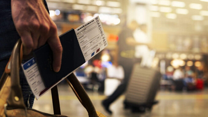 אדם טס לחו"ל ומחזיק בידו כרטיס טיסה